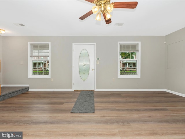 foyer entrance with ceiling fan and wood-type flooring