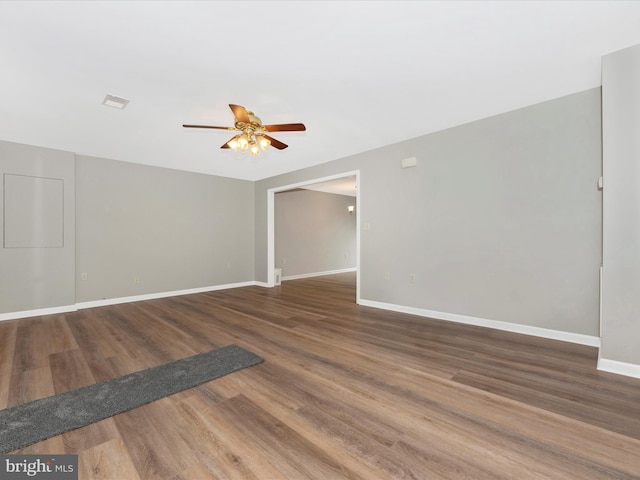 empty room featuring dark wood-type flooring and ceiling fan