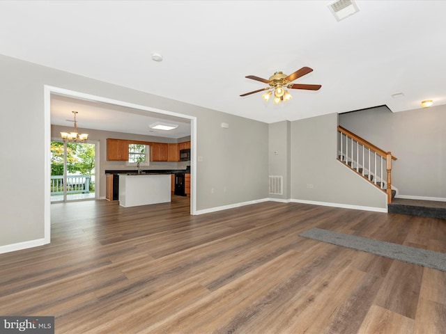 unfurnished living room featuring ceiling fan with notable chandelier, dark hardwood / wood-style floors, and sink