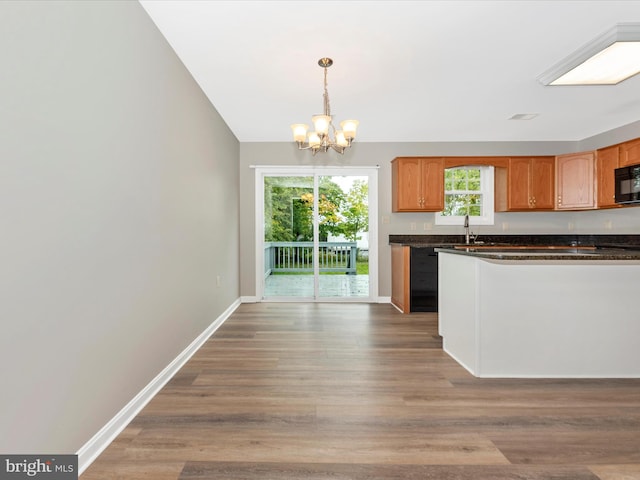 kitchen with pendant lighting, hardwood / wood-style floors, a notable chandelier, and sink