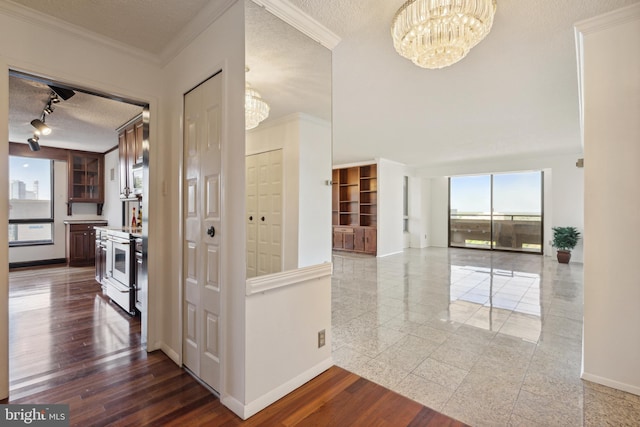 hall featuring crown molding, a wealth of natural light, dark wood-type flooring, and a textured ceiling