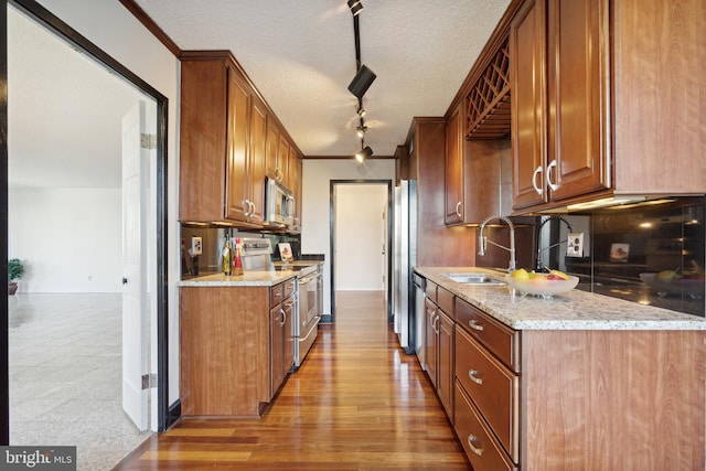 kitchen featuring light stone countertops, a textured ceiling, appliances with stainless steel finishes, and light hardwood / wood-style floors