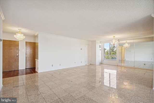 unfurnished room with crown molding, hardwood / wood-style floors, an inviting chandelier, and a textured ceiling