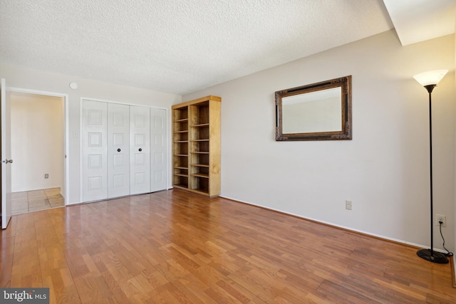 unfurnished bedroom featuring hardwood / wood-style floors and a textured ceiling