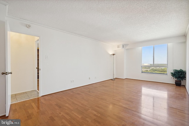 spare room with wood-type flooring and a textured ceiling