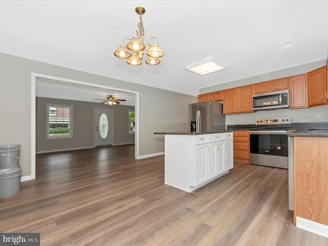 kitchen with ceiling fan with notable chandelier, decorative light fixtures, appliances with stainless steel finishes, and light hardwood / wood-style floors