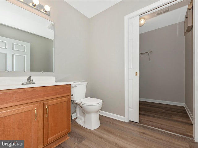 bathroom featuring wood-type flooring, vanity, and toilet