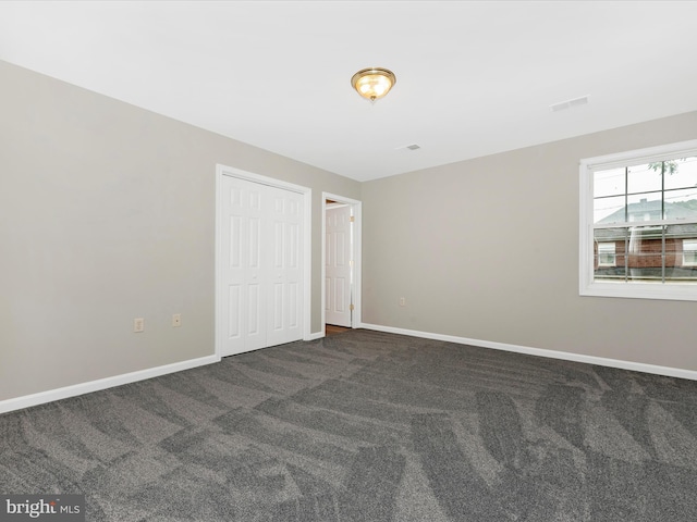 unfurnished bedroom with dark colored carpet