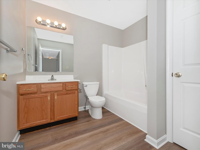 full bathroom with hardwood / wood-style floors, vanity, toilet, and  shower combination