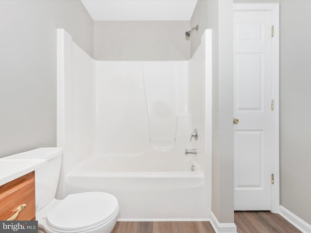 full bathroom with hardwood / wood-style flooring, toilet, vanity, and  shower combination