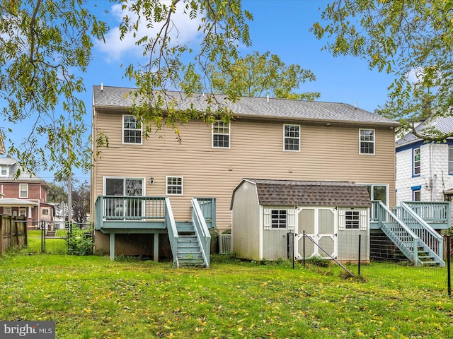 back of house with a wooden deck, a yard, and a shed