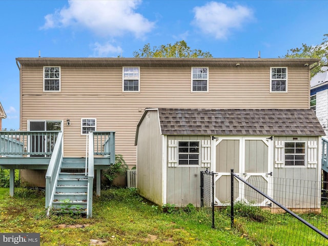 rear view of house with a yard and a wooden deck