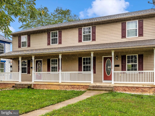 farmhouse-style home with a front yard and covered porch