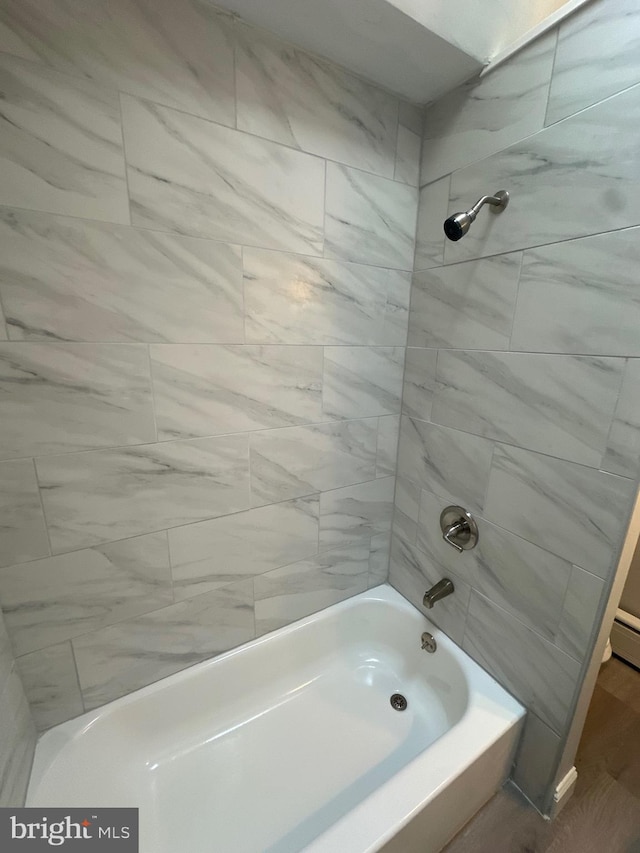 bathroom featuring hardwood / wood-style floors and tiled shower / bath