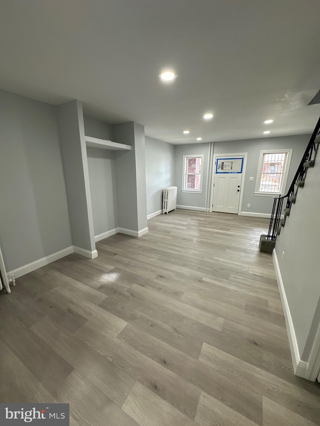 basement featuring radiator and light wood-type flooring