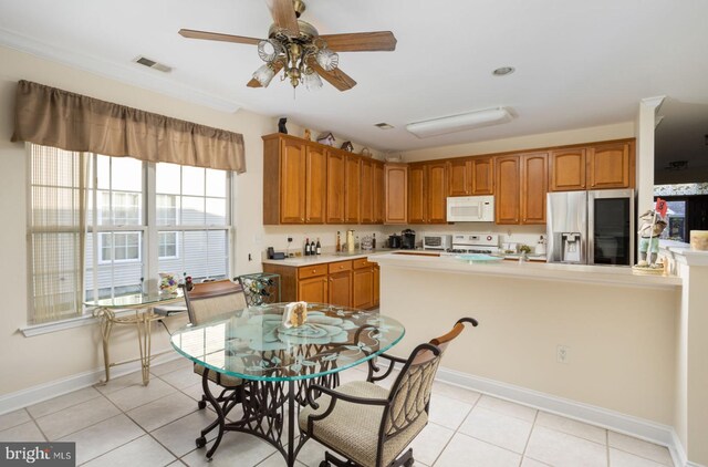 kitchen featuring ceiling fan, light tile patterned floors, and white appliances