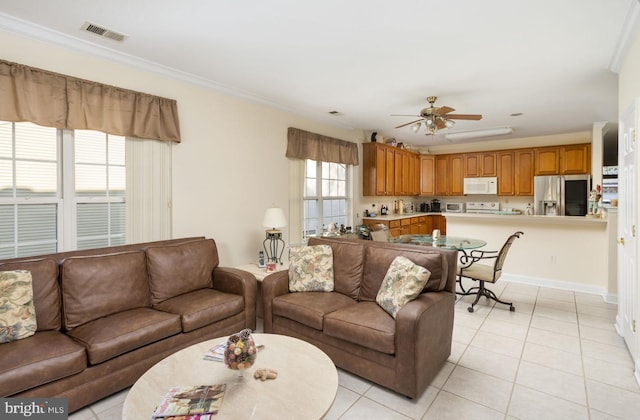 tiled living room featuring ceiling fan, ornamental molding, and a wealth of natural light