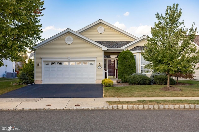 view of front facade featuring a front lawn, central AC unit, and a garage