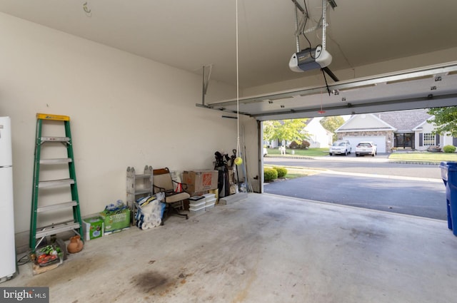 garage with a garage door opener and white fridge