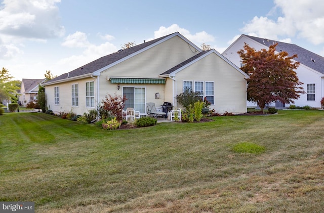 rear view of property with a lawn