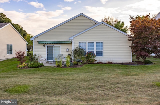 rear view of house featuring a patio area and a yard