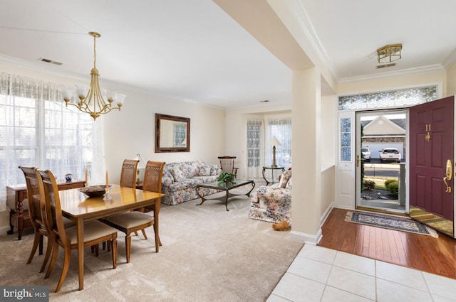 entrance foyer with crown molding, light hardwood / wood-style floors, and an inviting chandelier