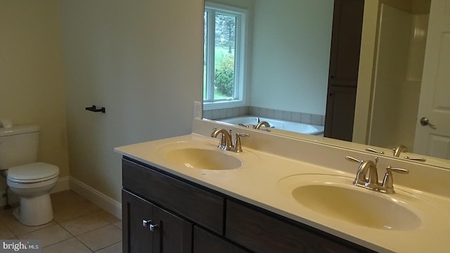 bathroom with vanity, tile patterned flooring, toilet, and a tub