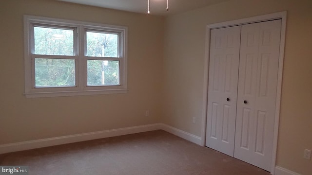 unfurnished bedroom with a closet and carpet floors