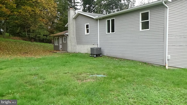 view of home's exterior featuring central AC unit and a yard