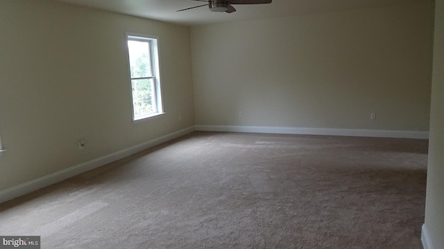 carpeted spare room featuring ceiling fan