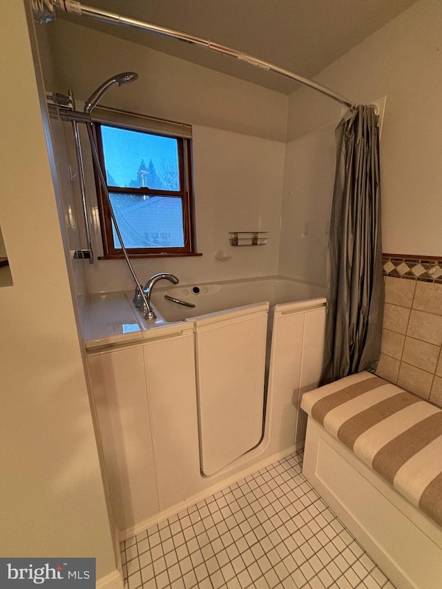 bathroom featuring shower / bath combo with shower curtain, tile patterned floors, and sink