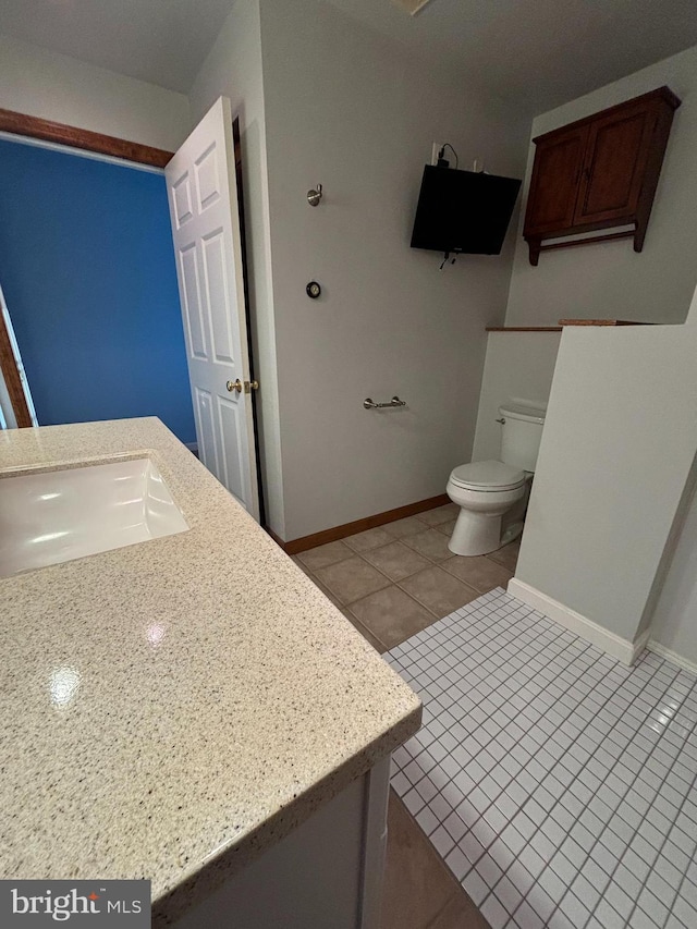 bathroom with tile patterned flooring, vanity, and toilet