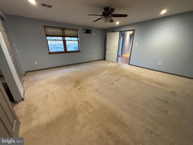 unfurnished room with light colored carpet and ceiling fan