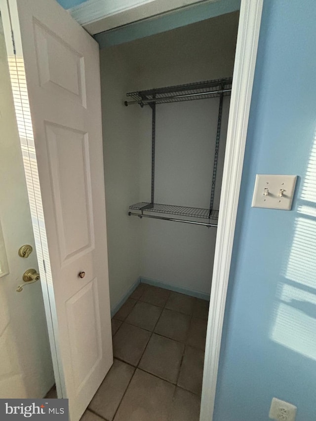 walk in closet with light tile patterned floors