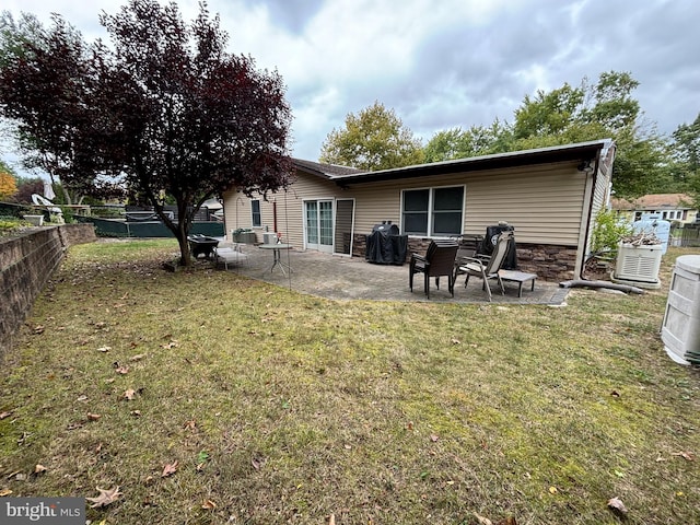 back of property featuring a patio and a lawn