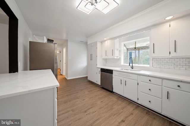 kitchen with sink, light hardwood / wood-style flooring, white cabinetry, and stainless steel dishwasher