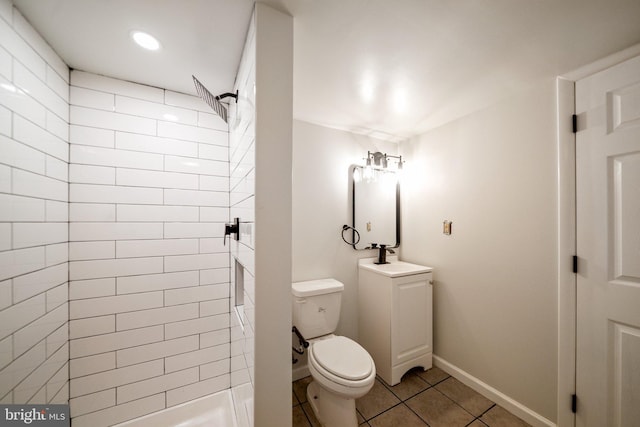 bathroom with tile patterned flooring, tiled shower, and toilet