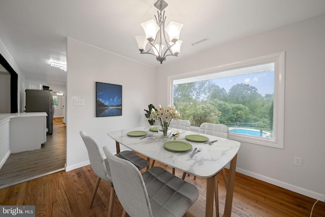 dining area with a notable chandelier and dark wood-type flooring