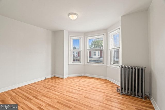 empty room with radiator and light hardwood / wood-style floors