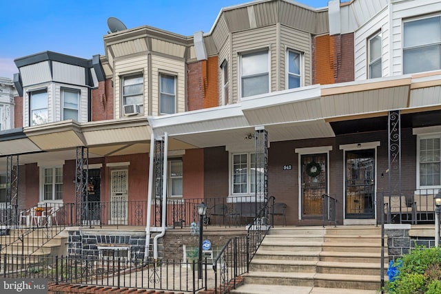 townhome / multi-family property featuring cooling unit and a porch