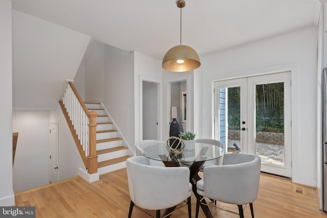 dining area with light hardwood / wood-style floors and french doors