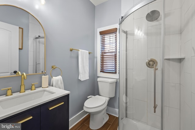 bathroom with walk in shower, vanity, hardwood / wood-style floors, and toilet