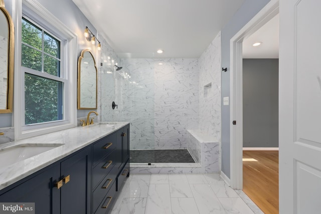 bathroom with a tile shower, vanity, and hardwood / wood-style flooring