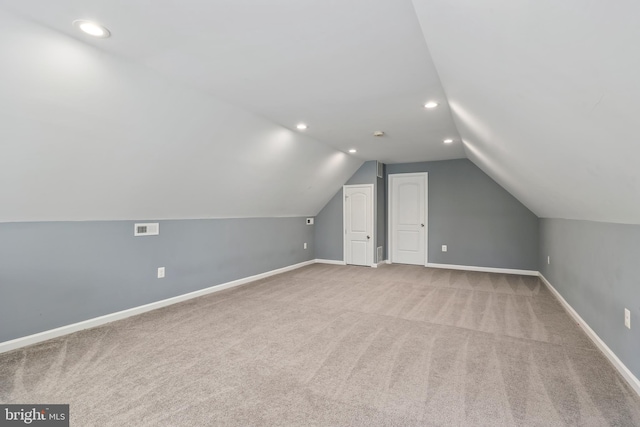 bonus room featuring lofted ceiling and light colored carpet