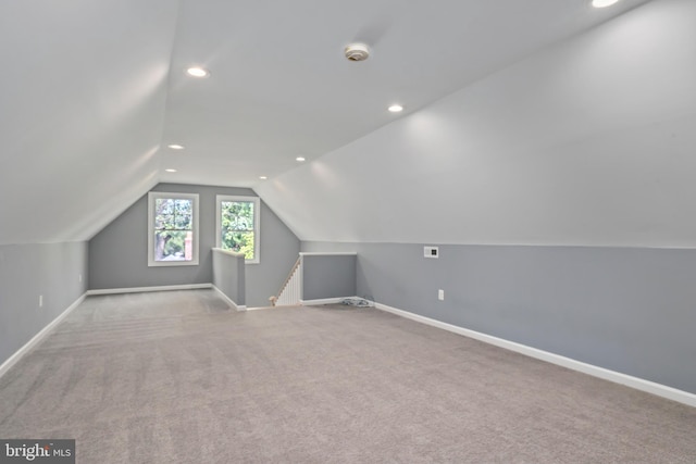 additional living space with vaulted ceiling and light colored carpet