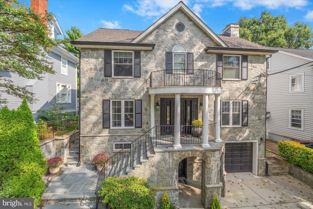 view of front of property with a garage and a balcony