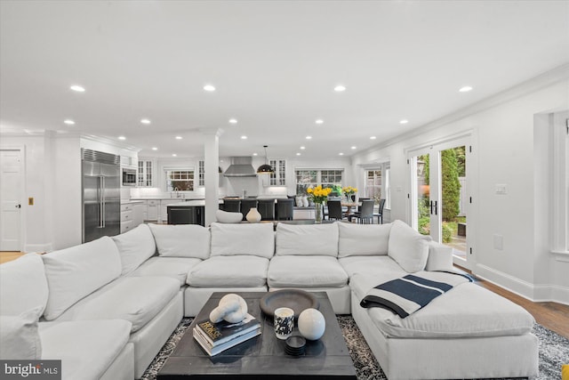 living room featuring crown molding, hardwood / wood-style floors, and decorative columns