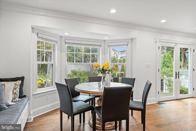 dining space featuring wood finished floors, baseboards, ornamental molding, and recessed lighting