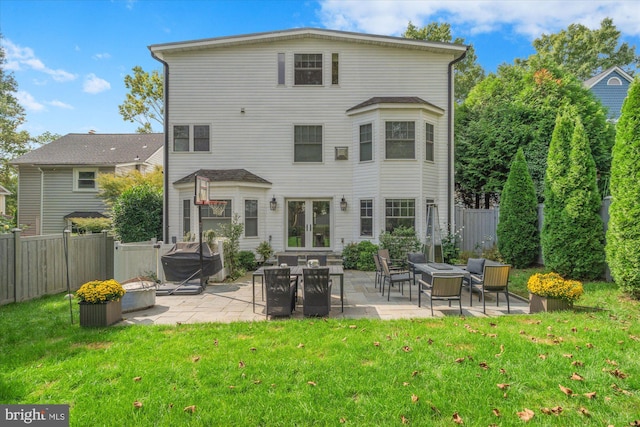 back of house featuring an outdoor fire pit, a yard, and a patio area