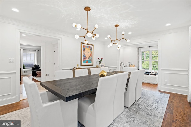 dining area with plenty of natural light, ornamental molding, hardwood / wood-style floors, and a notable chandelier